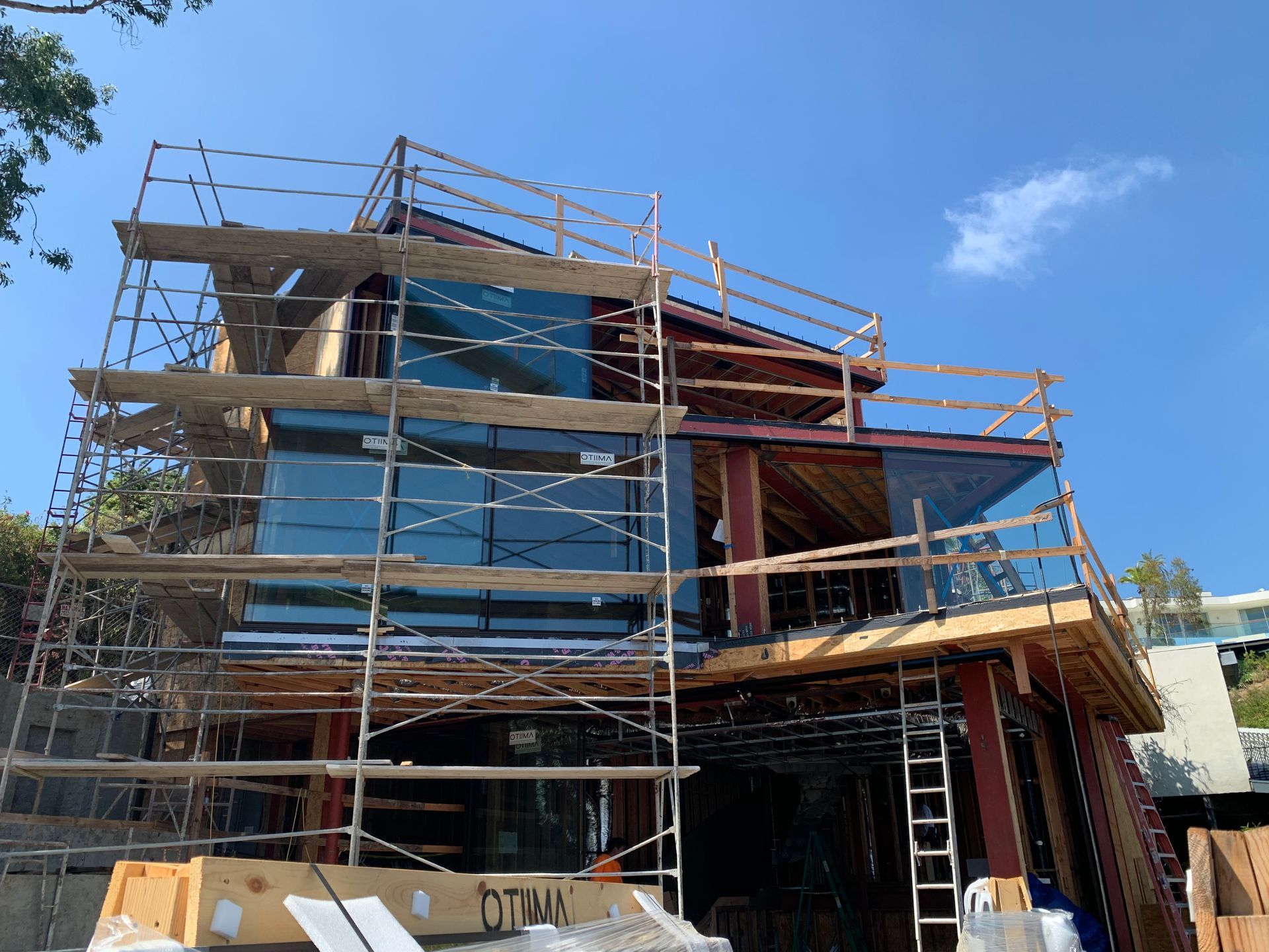 Scaffolding around a partially built house with blue sky overhead