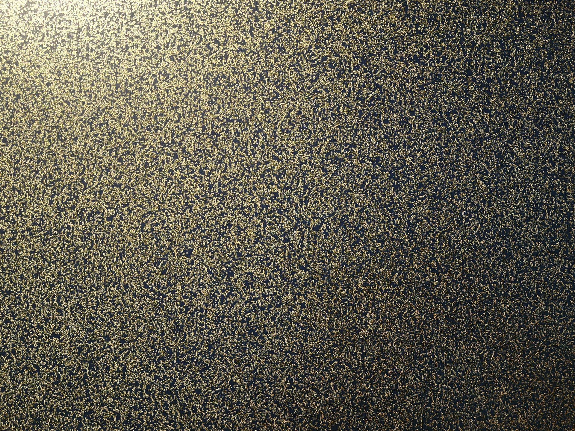 Speckled gold and dark textured surface, abstract background