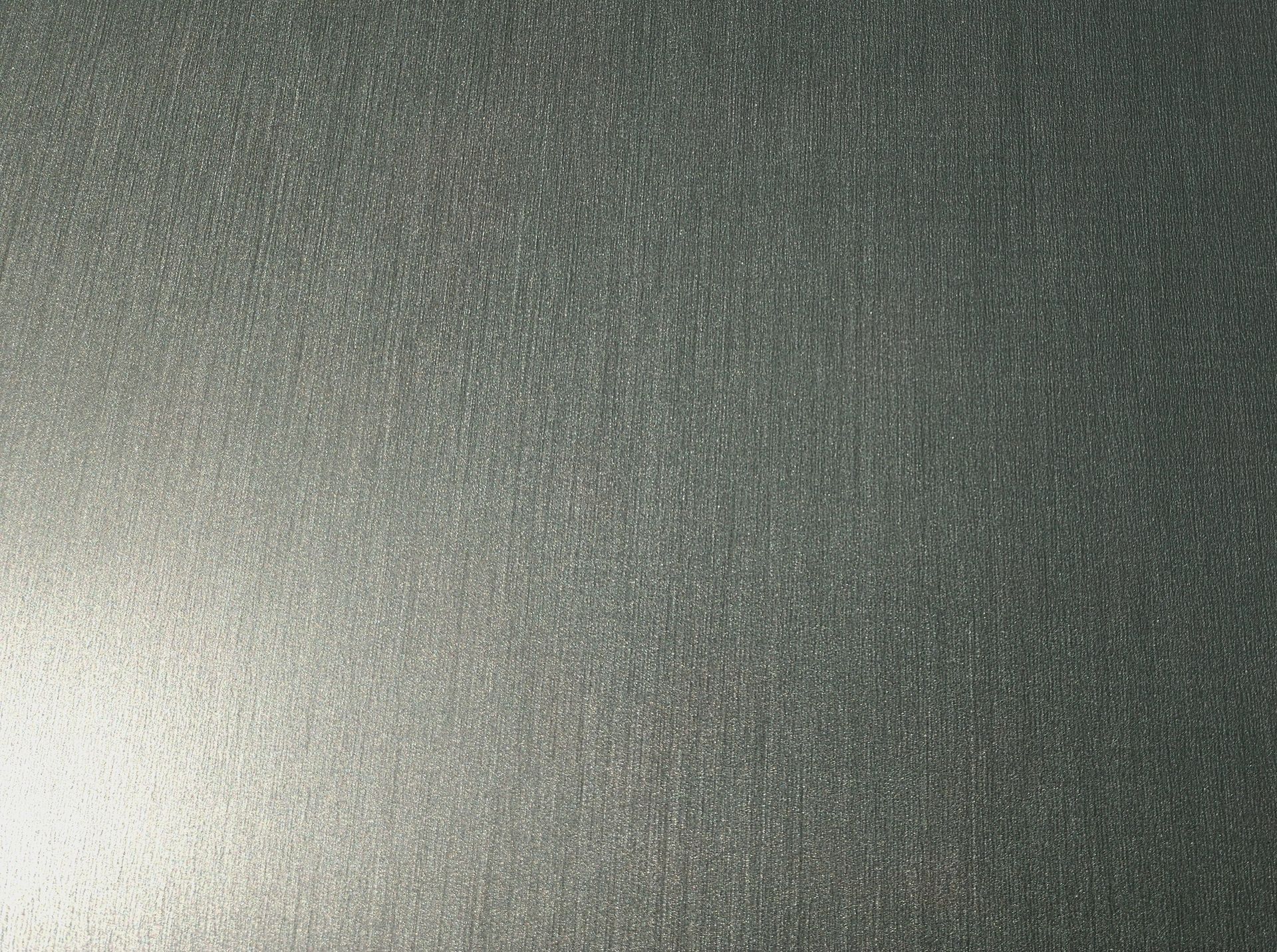 Close-up of a gray textured surface with a bright light reflection on the left side