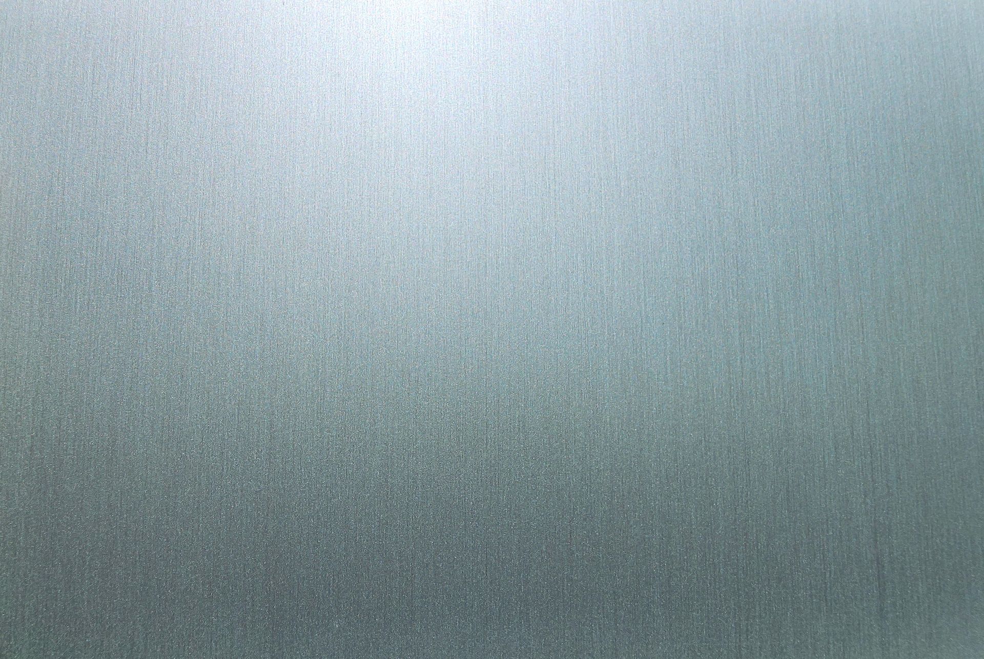 Gray textured metallic surface with subtle light gradient and fine vertical scratches