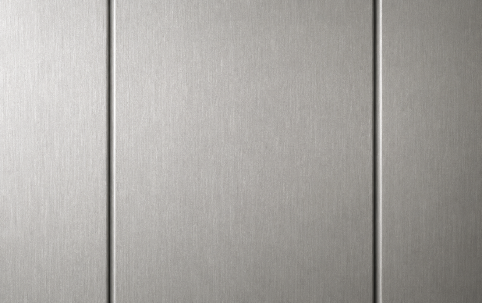 Close-up of brushed metal panels with vertical seams and a gray finish