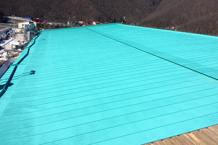 Bright turquoise roof on a building in a mountain area under clear daylight