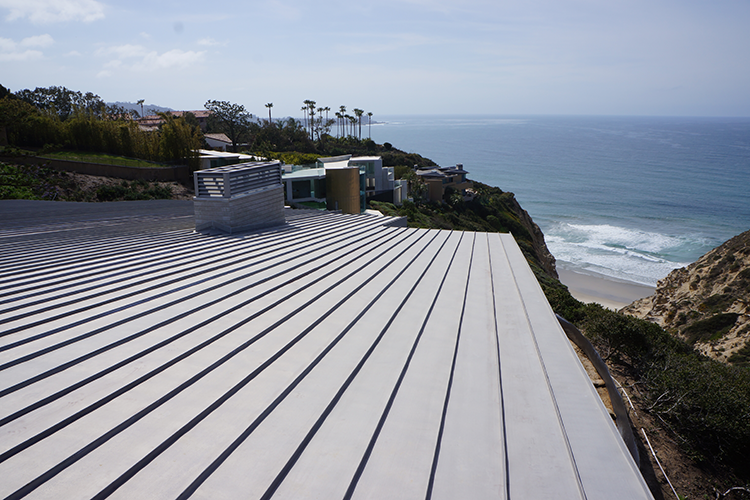 Rooftop deck overlooking the ocean with lounge chairs and a cliffside view