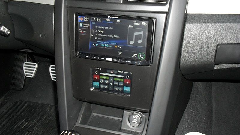 Car stereo and climate control panel in a car interior, with pedals visible on the left.