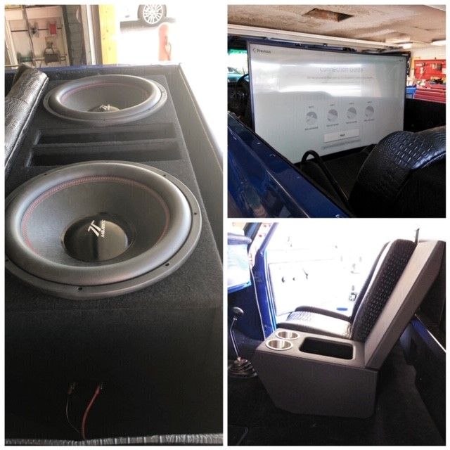 Custom car audio setup with two large subwoofers and a speaker enclosure in a vehicle interior
