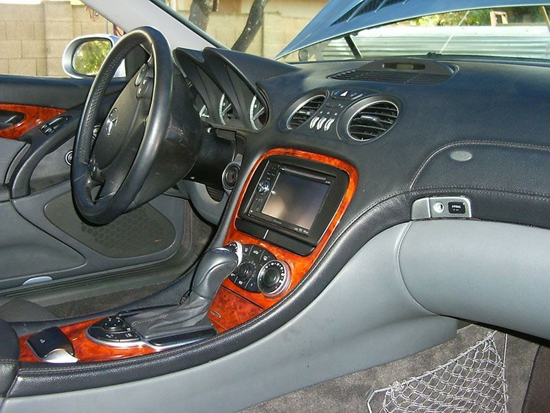 Car interior with black dashboard, orange center console trim, steering wheel, and front seats