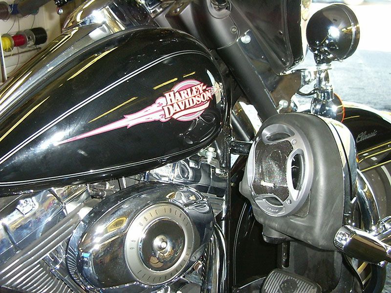 Close-up of a black Harley-Davidson motorcycle fuel tank and chrome engine with a side mirror