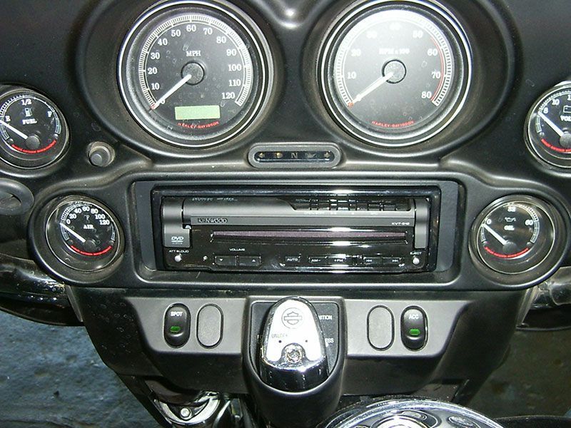 Car dashboard with gauges, radio, and control knobs in a black center console