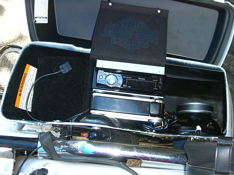Open case with a tuba, trumpet, and other brass instrument parts inside.