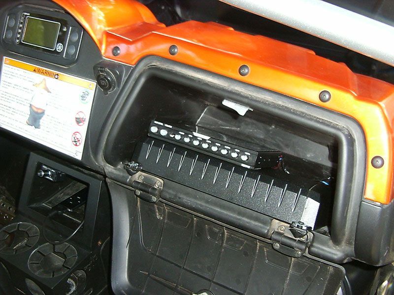 Orange vehicle dashboard with open fuse panel under the steering area