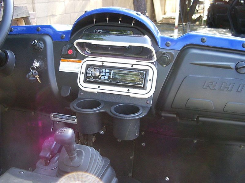 Truck dashboard with blue and black interior, center radio, cup holders, and manual gear shift
