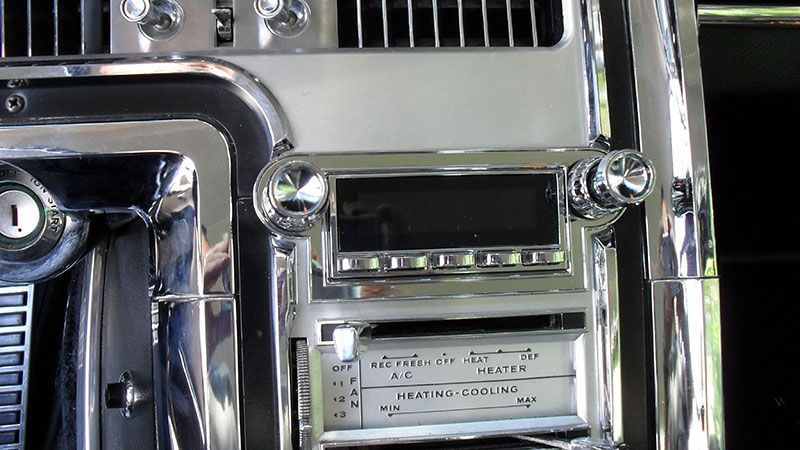 Chrome car dashboard with radio and vents, showing a close-up of control panel buttons