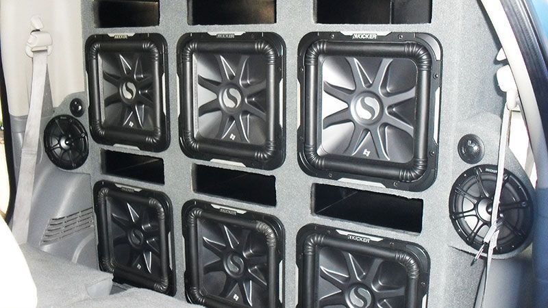 Six square subwoofers mounted in a white car trunk audio system
