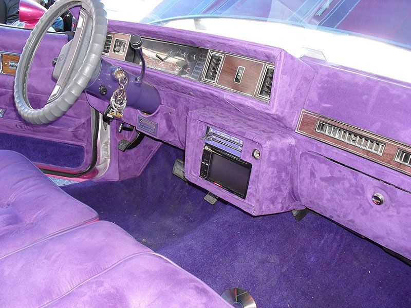 Purple car interior with matching dashboard, steering wheel, and upholstery.