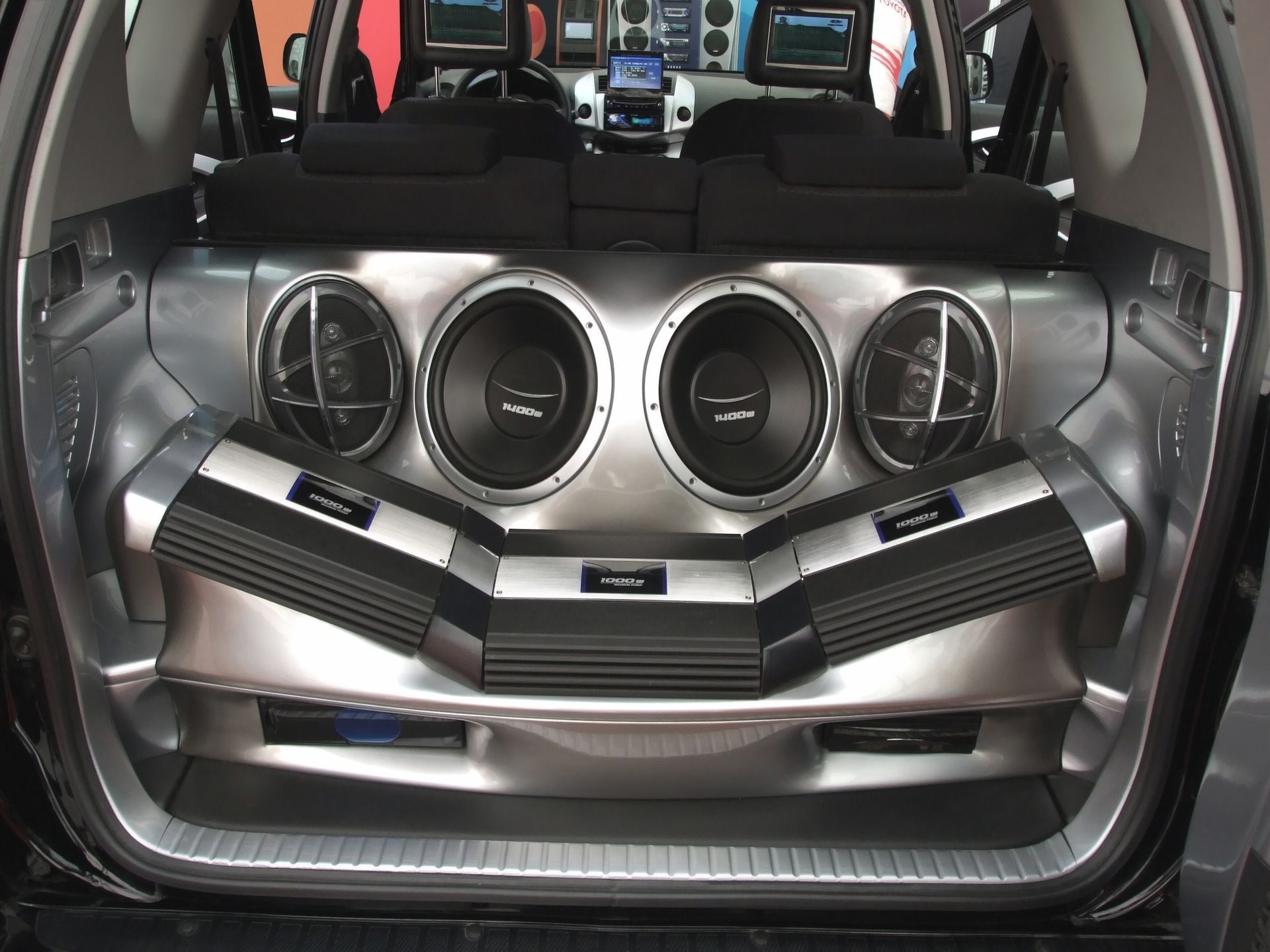Car trunk with a custom silver speaker system and four round speakers installed in the rear