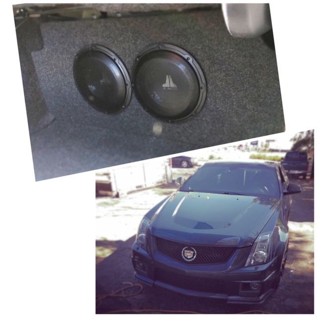 Black Cadillac sedan with custom trunk subwoofers shown in a small inset above the car.