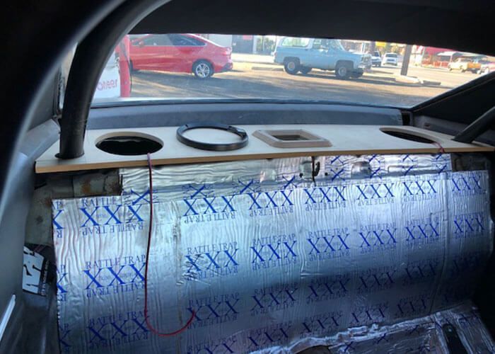 Car interior with a foil-covered dashboard and blue X marks on the windshield