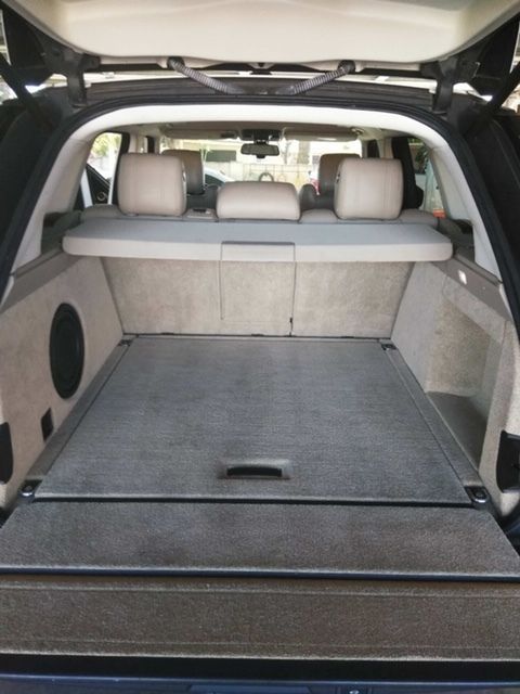 Open SUV cargo area with flat black cargo floor and folded rear seats visible.