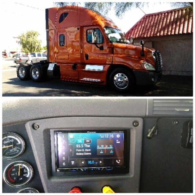 Orange semi-truck exterior and dashboard with a touchscreen display inside.
