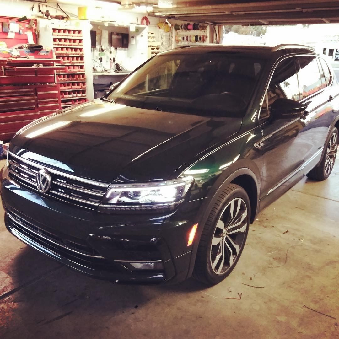 Black SUV parked in a garage, with tools and shelves visible in the background