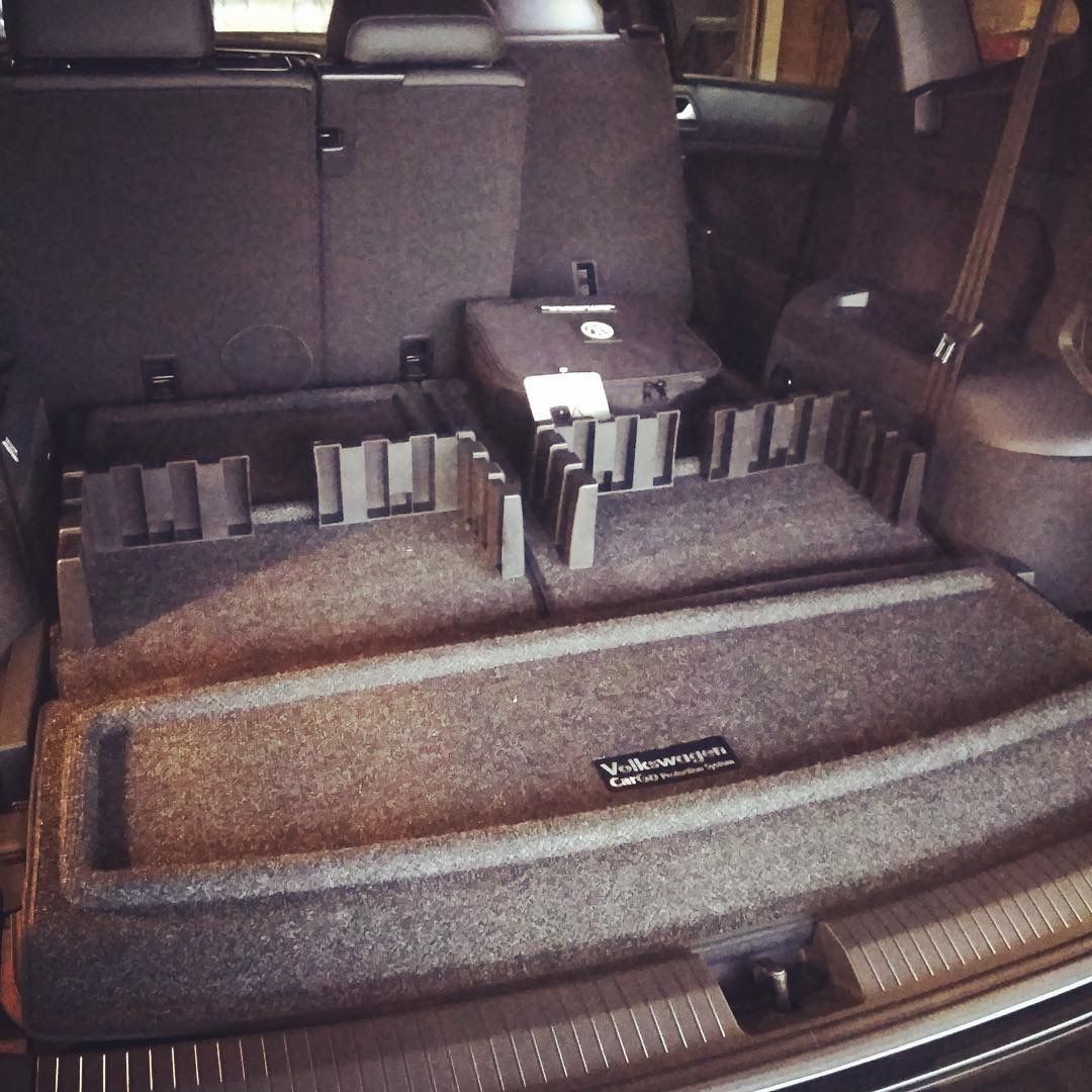 Cargo area with a gray storage organizer and black dividers in the back of a vehicle.