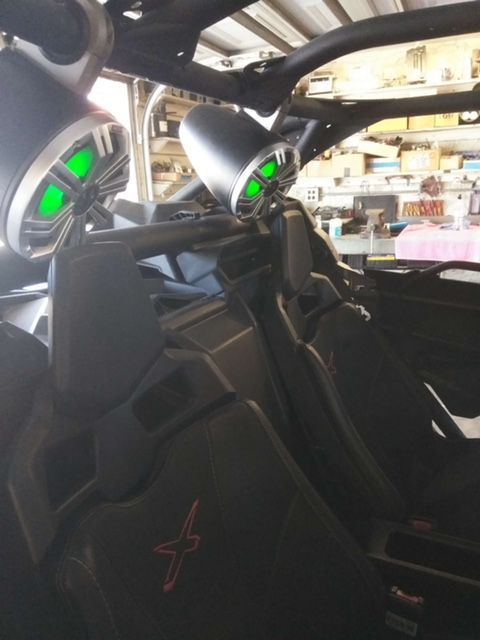Black race car cockpit with green-lit gauges and bucket seats indoors