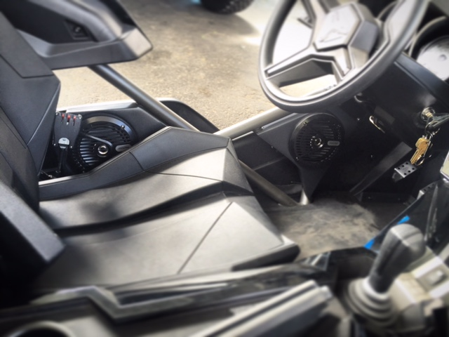 Interior of a black sports car, showing the steering wheel, center console, and bucket seats.