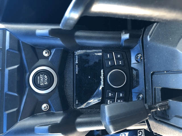 Car center console with drive mode dial, controls, and a keyless start button near the gear selector.