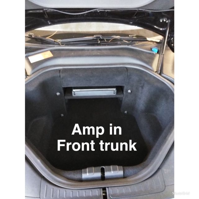 Open front trunk of a car with an amp installed inside the compartment.
