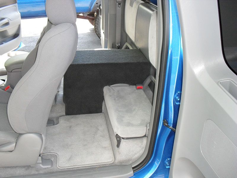 Light gray vehicle interior with a folded rear seat and open blue door