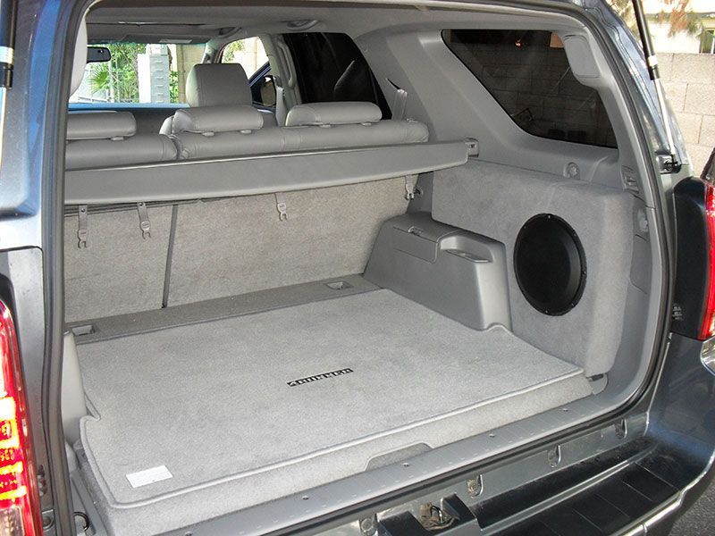 Open SUV cargo area with folded rear seats and gray carpeted trunk floor