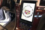 Car dashboard display showing the Cadillac emblem on a center touchscreen