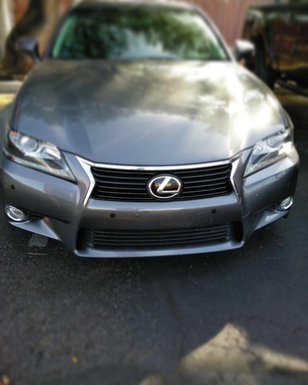 Front view of a silver Lexus sedan parked on a street in daylight