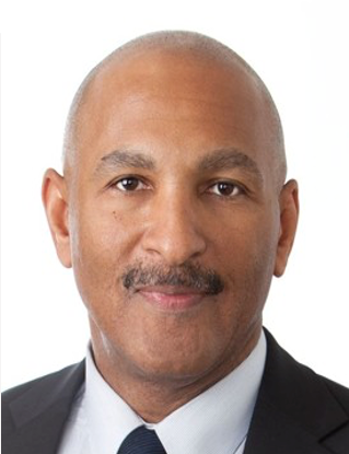 A man with a mustache is wearing a suit and tie