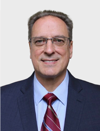 A man in a suit and tie is smiling for the camera