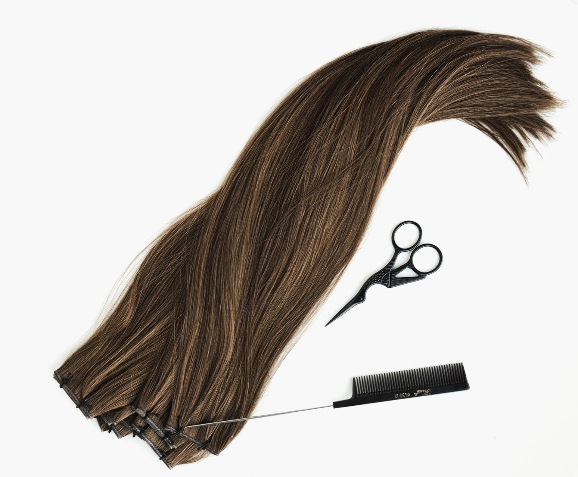 Brown hair extension with scissors and a comb on a white background