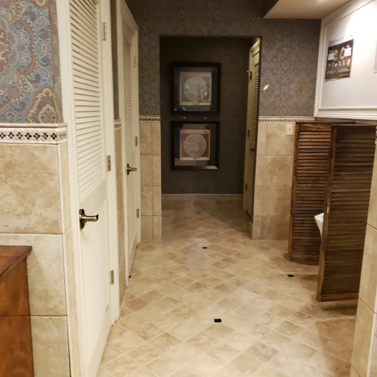 Hallway with three doors, patterned wallpaper, tile flooring, and decorative wooden screens. Hallway with three doors, patterned wallpaper, tile flooring, and decorative wooden screens.