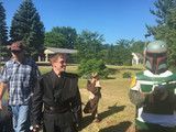 Two people and a Boba Fett figure standing outdoors on a sunny lawn