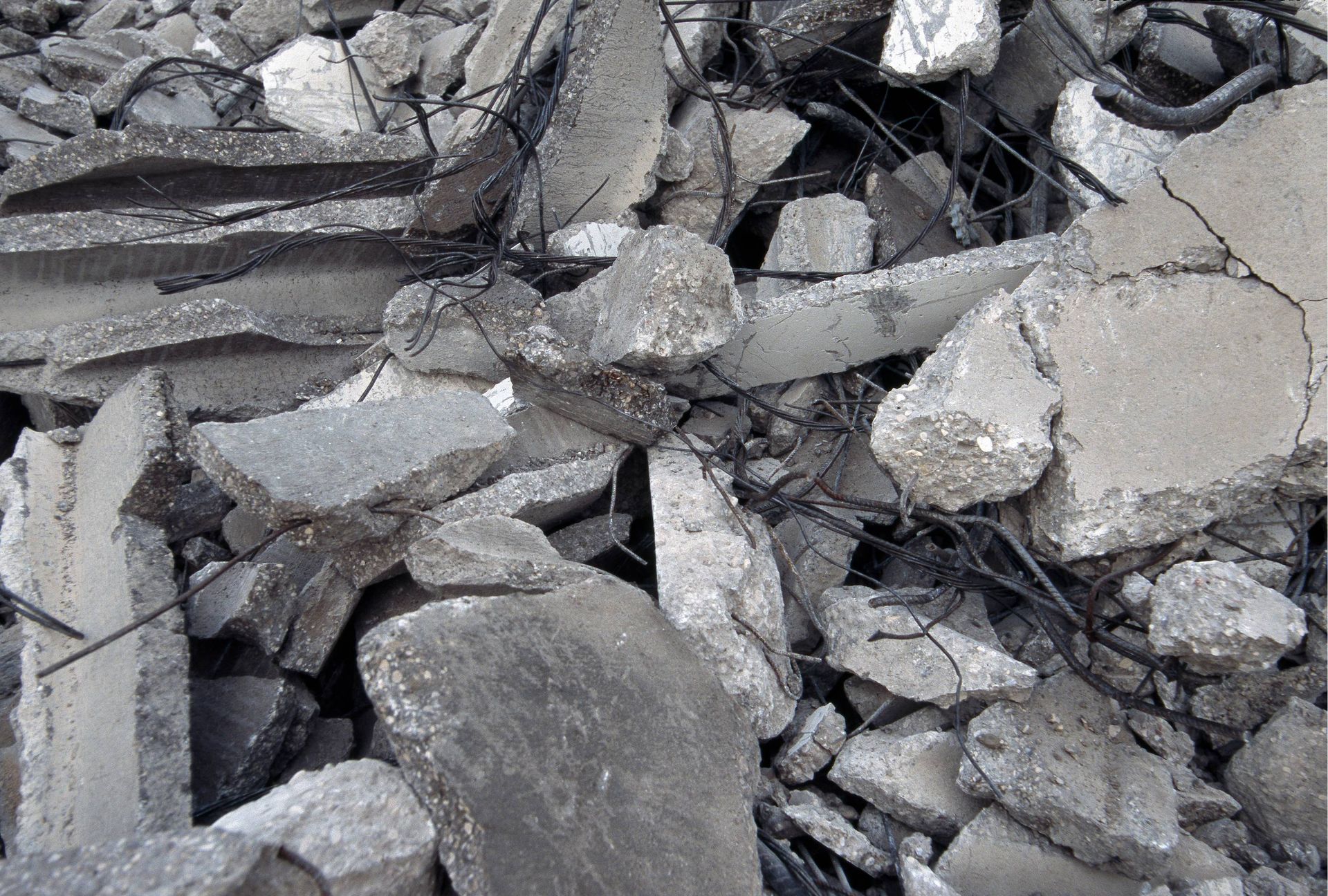 Pile of broken gray concrete rubble and debris