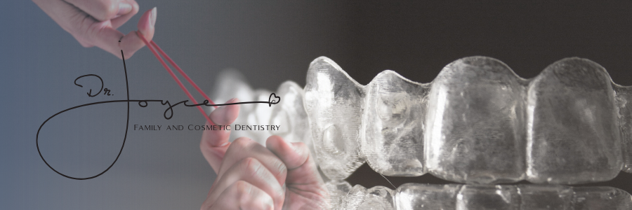 A person is holding a clear brace on their teeth.