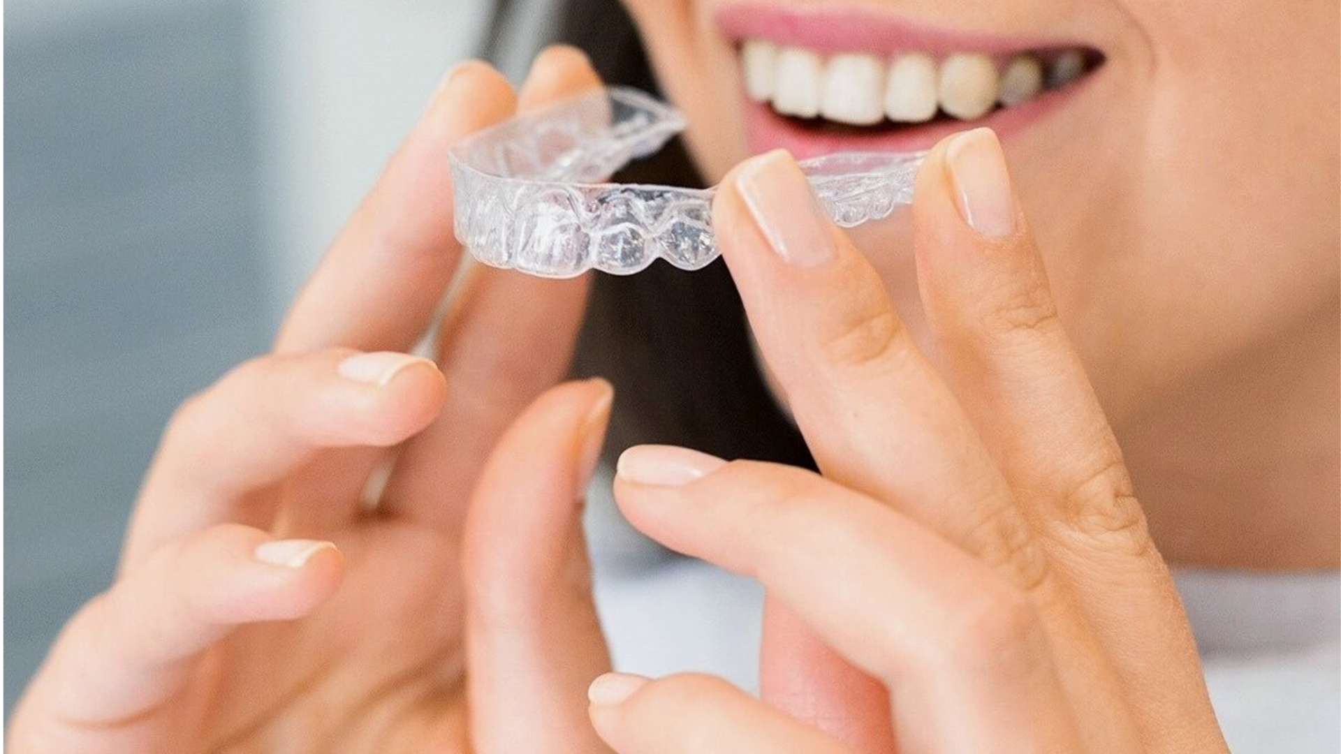 Close-up of braces being adjusted on teeth with a dental mirror and gloved hands