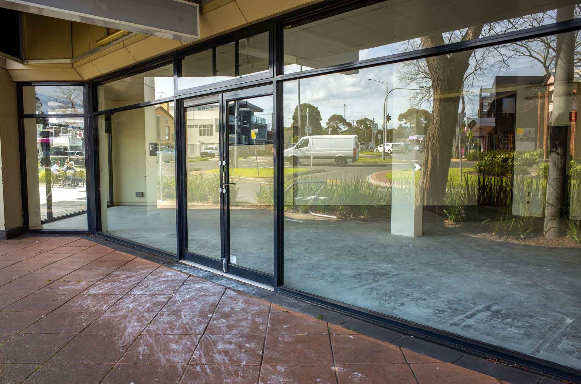 Empty commercial storefront with large glass windows and doors. Empty commercial storefront with large glass windows and doors.
