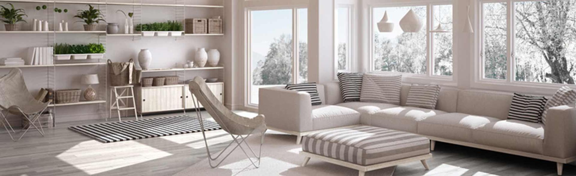 A living room with a couch , chair , ottoman and shelves.