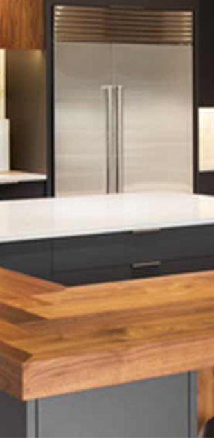 A kitchen with a stainless steel refrigerator and a wooden counter top.