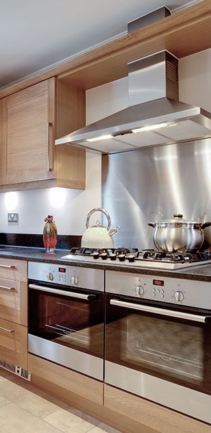 A kitchen with stainless steel appliances and wooden cabinets.