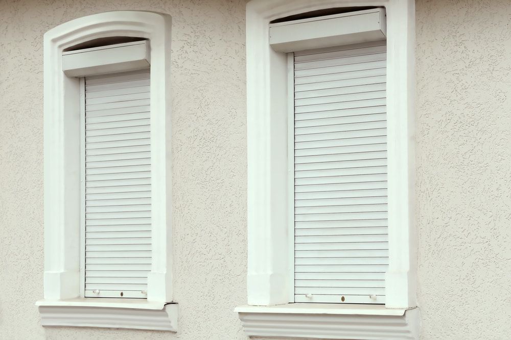 Two Windows With Roller Shutters on a White Building — Whitsunday Screens & Grilles In Cannonvale, QLD