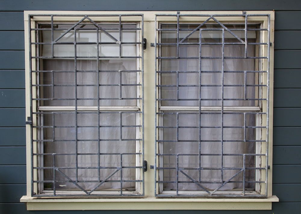 A Window With a Metal Grill on It is on a Gray Wall — Whitsunday Screens & Grilles In Bowen, QLD