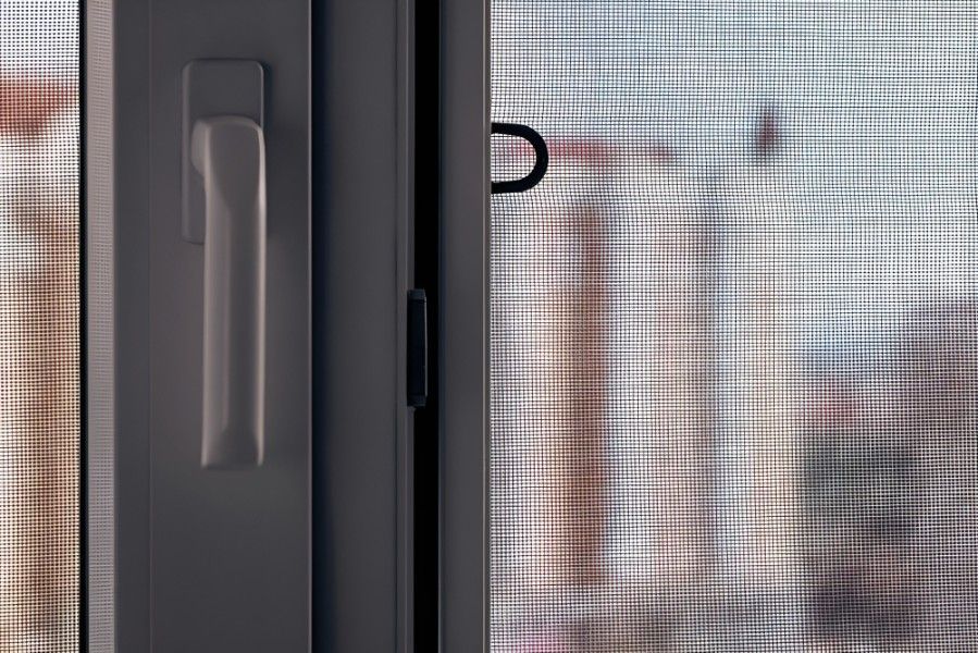 A Close Up of a Sliding Screen Door With a Handle — Whitsunday Screens & Grilles In Bowen, QLD