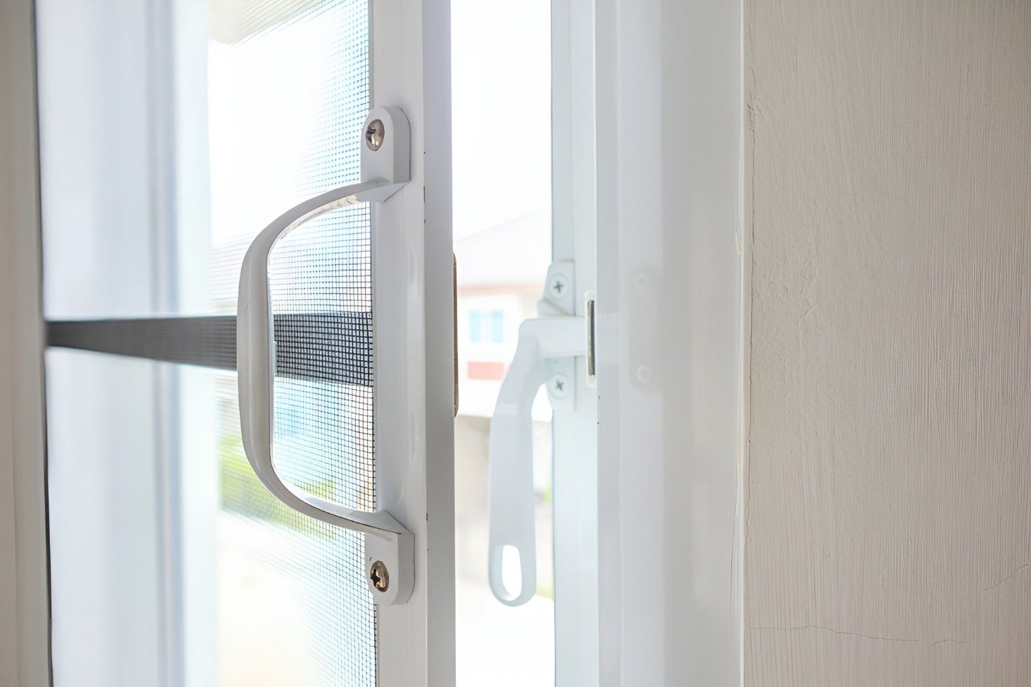A Close Up of a White Sliding Glass Door With a Handle — Whitsunday Screens & Grilles In Cannonvale, QLD