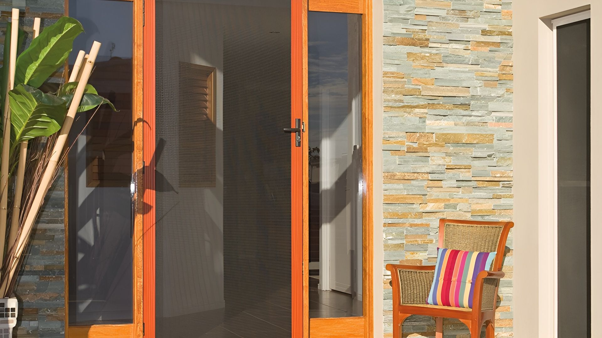 A Chair is Sitting in Front of a Sliding Glass Door — Whitsunday Screens & Grilles In Proserpine, QLD